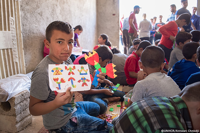 自分で工作した作品を見せてくれるシリアの少年