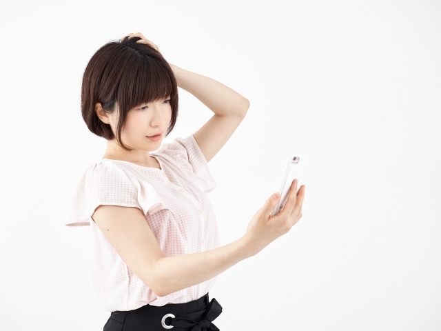 スマホを見て困っている女性