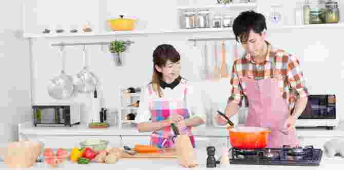キッチンで、料理男子とならんでいる女性