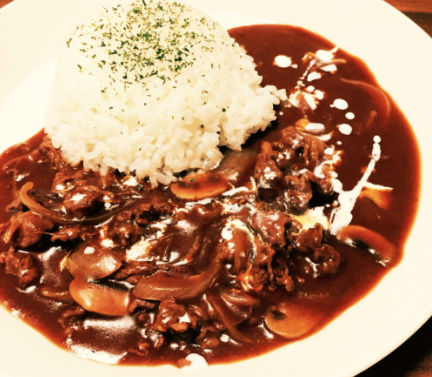 赤褐色のビーフストロガノフとみじん切りパセリがのったご飯