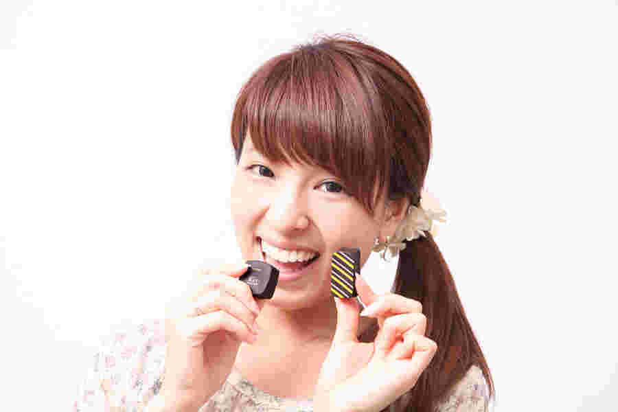 お腹が空いてチョコレートを食べる女性