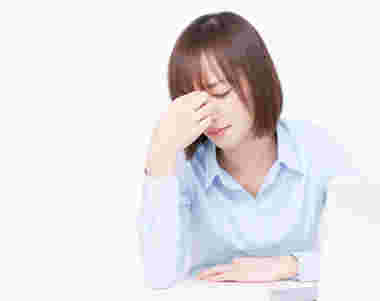 目頭を押さえる女性