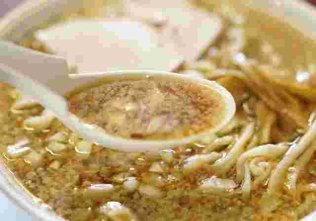 杭州飯店のラーメンのスープをすくいあげた様子