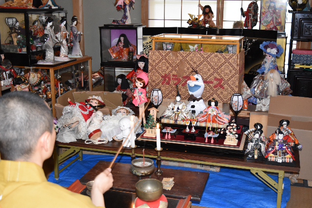 洒水器(しゃすいき)を使って供養する住職の写真