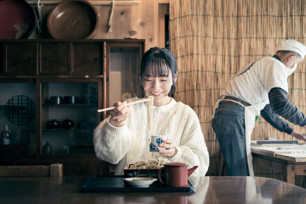 「100年そばの会」のメンバーが打ってくれたそばを女性が食べている写真