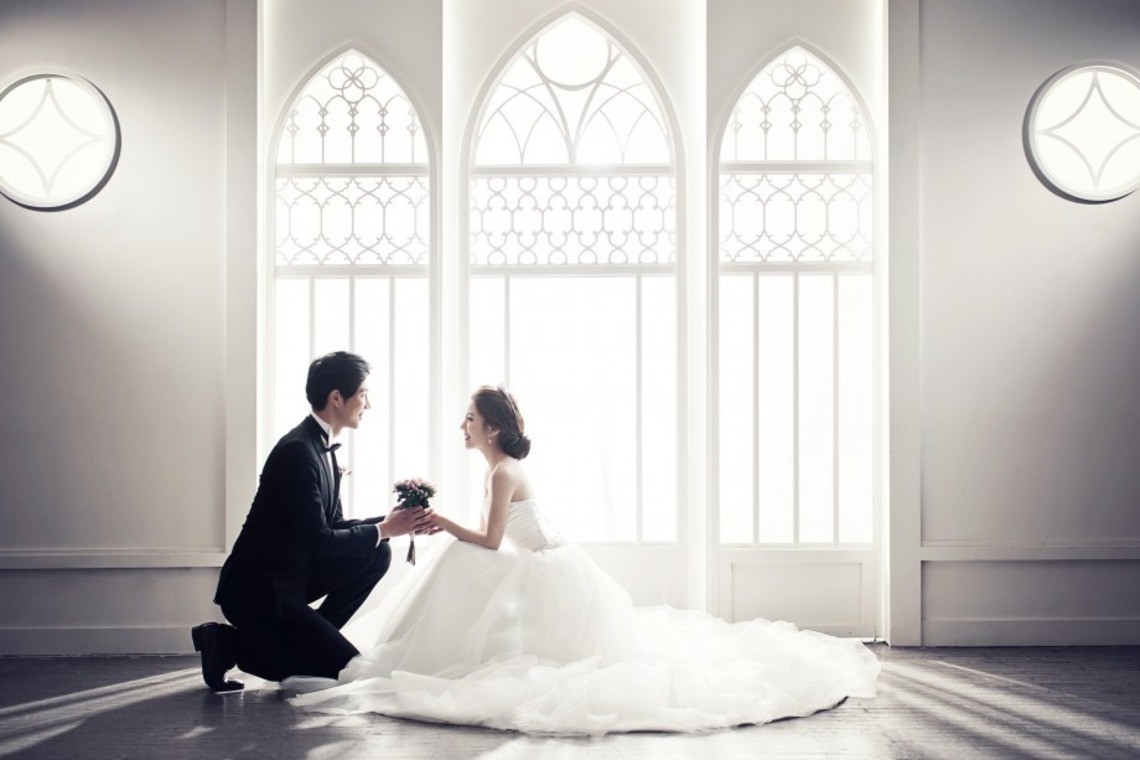 A wedding couple in korea posing with a bouquet