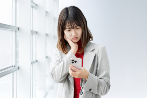 スマホ見て悩む女性_情報に迷う