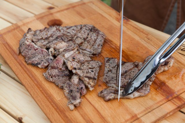 トングで肉をおさえながら包丁でダイナミックに切るモテテクニック。たけだバーベキューさん、さすがに上手です