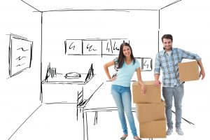 Attractive young couple with moving boxes against kitchen sketch