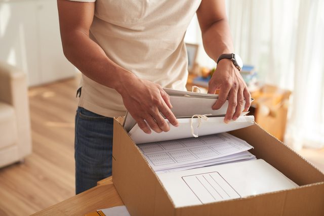 Young Man Sorting Box of Documents