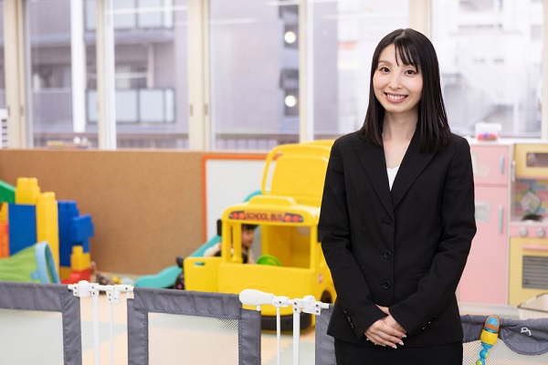 保育園にいるスーツを着た女性