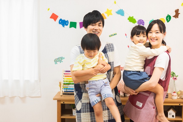 子どもを抱っこしている若い男性と女性