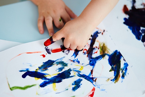 子どもの手に絵の具がついている画像