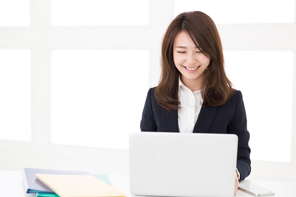 パソコンで作業する笑顔の女性