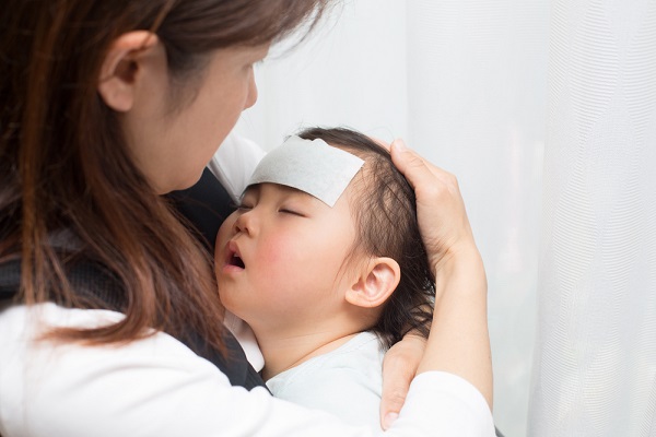 熱を出した子どもを心配する母親の写真