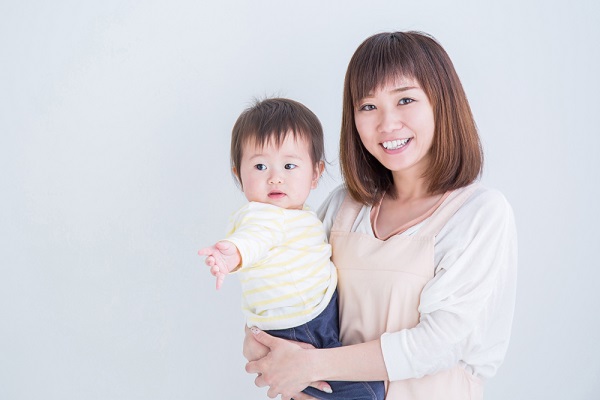 子どもを抱っこしている保育士の写真