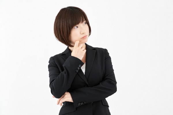スーツを着て考え事をしている女性の写真