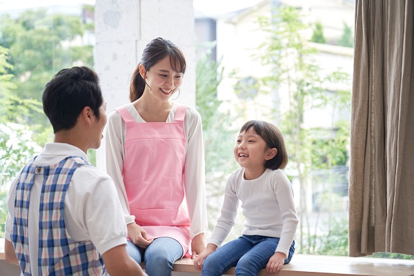 子どもと笑顔で話す保育士