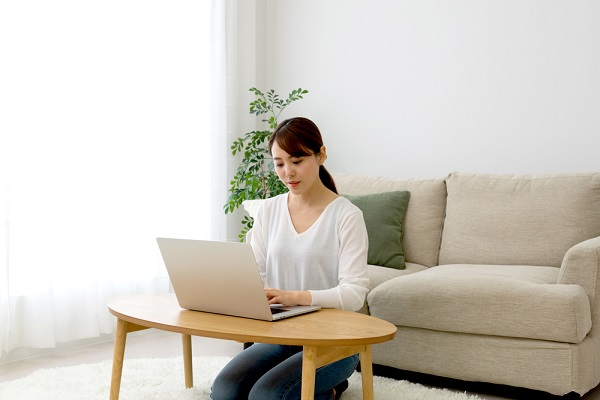 部屋でパソコンを操作する女性