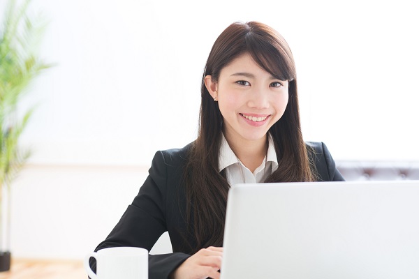 パソコンの前で笑顔の女性