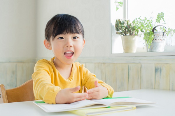 絵本を見て笑う女の子の写真