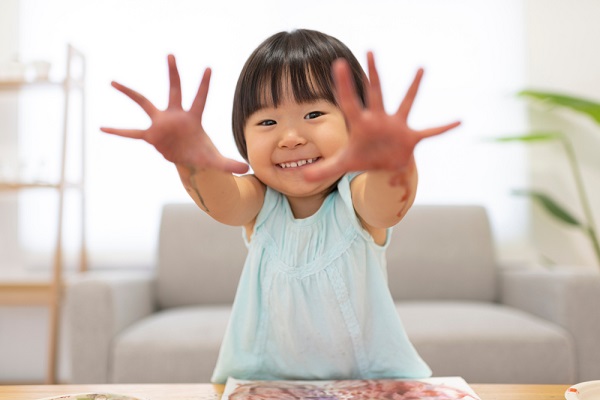 絵の具を手のつけてお絵かきする女の子