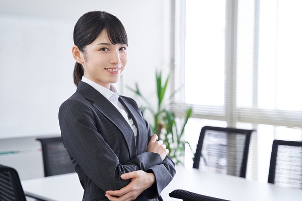 腕を組んでいるスーツの女性