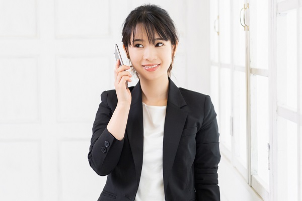 スーツ姿で電話をしている女性