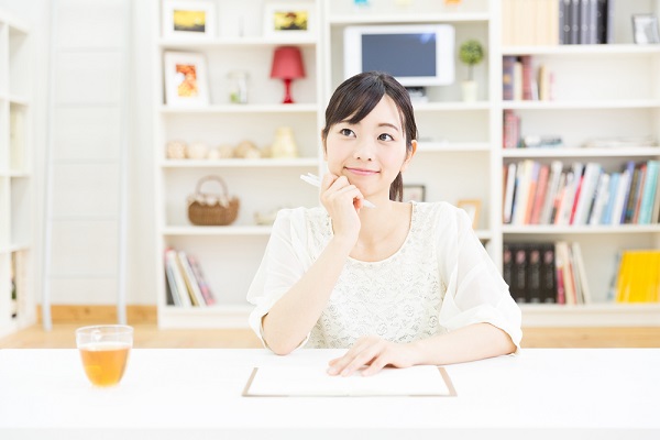 ペンを持って考えている女性