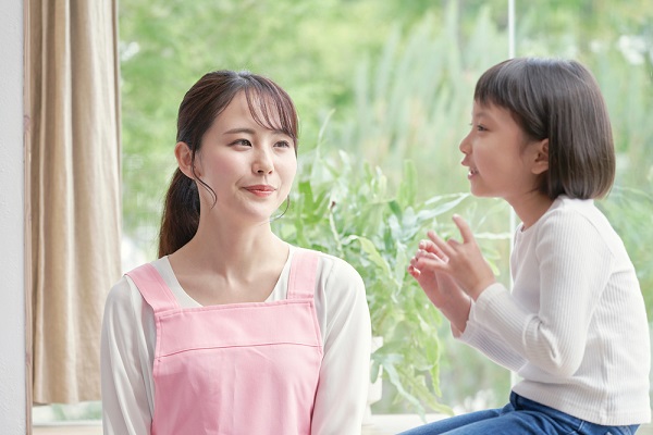 子どもを見つめる保育士