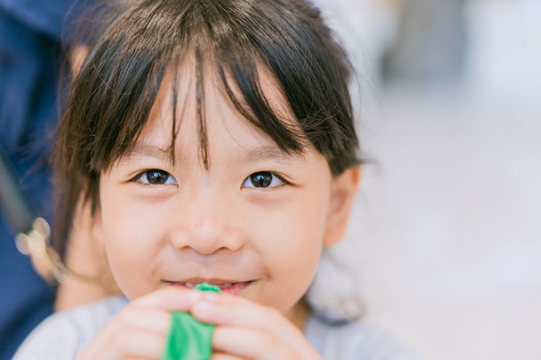 風船を膨らませようとしている子ども