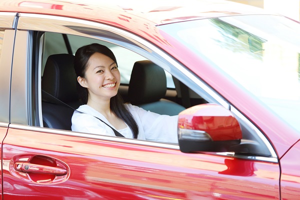 赤い車に乗っている女性