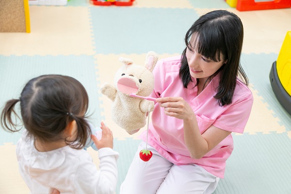 パペットを使って子どもに教える保育士さん