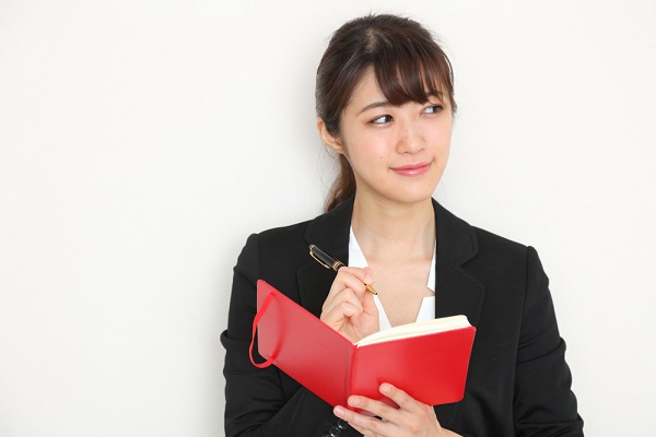 メモ帳を持っている女性