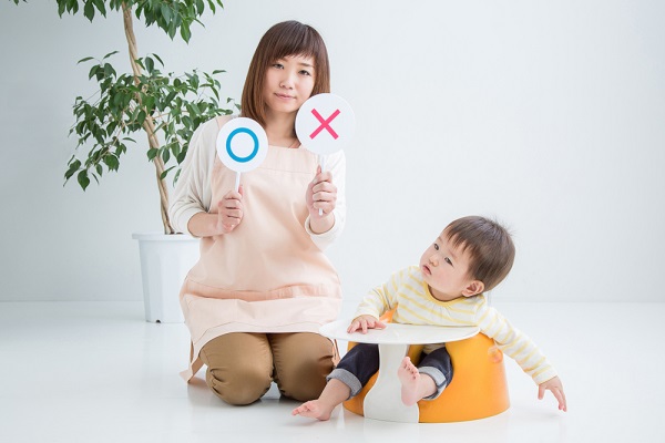 マルバツを持つ保育士