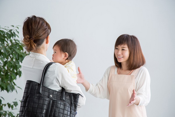 降園する子どもを見送る保育士