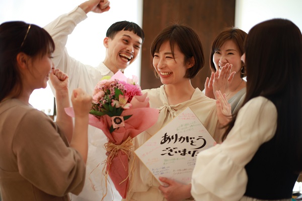 周りの人から花束を受ける保育士