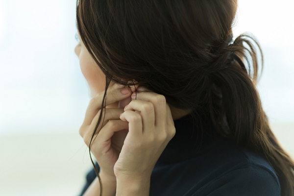 アクセサリーをつける女性