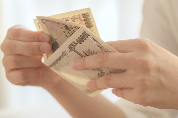 お金を数える女性