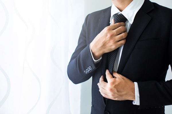 就活でネクタイをつける男性