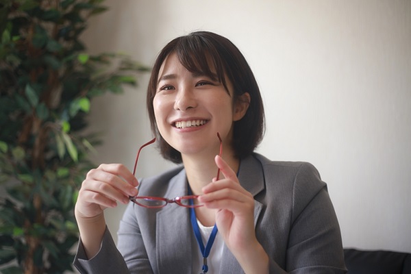 メガネをかけようとする女性