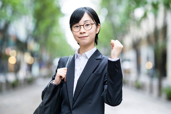 スーツを着てガッツポーズの女性