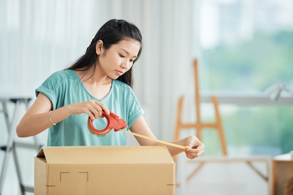 引っ越しで荷造りをする女性