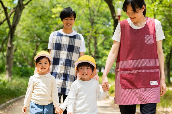 保育士と散歩する子ども