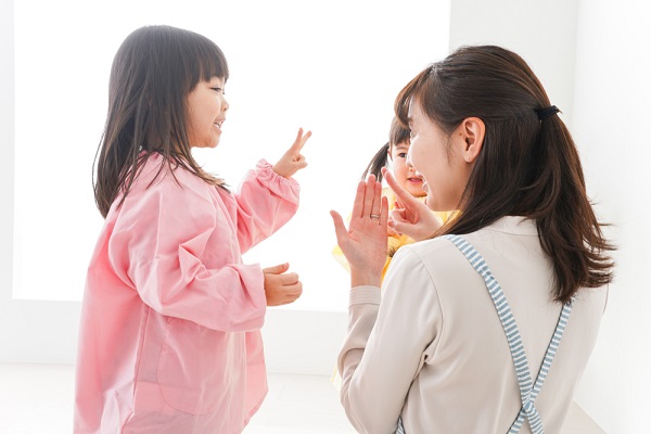 笑顔で遊ぶ保育士と子ども