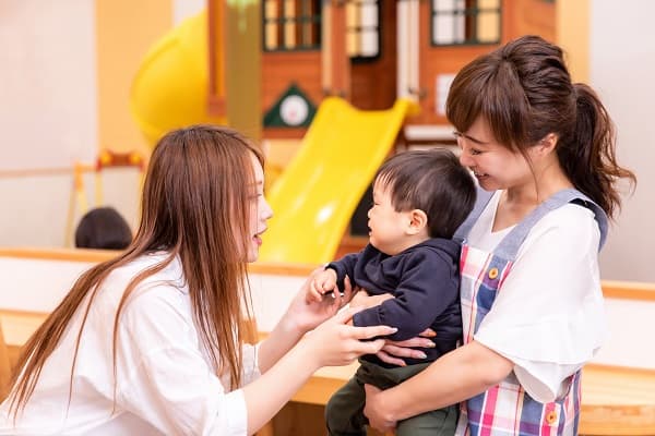 保護者、子どもと触れ合う保育士