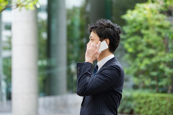 電話をかけるスーツの男性