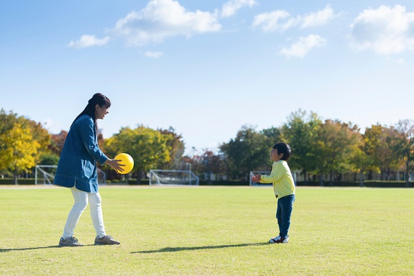 ボールで遊ぶ大人と子どもの写真