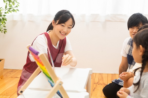 子どもに絵本を見せる先生