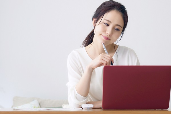 パソコンを見ながら悩んでいる様子の女性